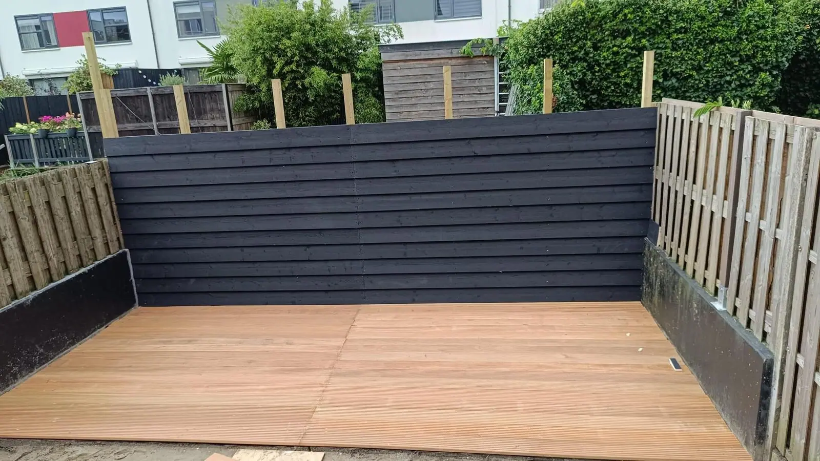 Houten terras en schutting in moderne tuin