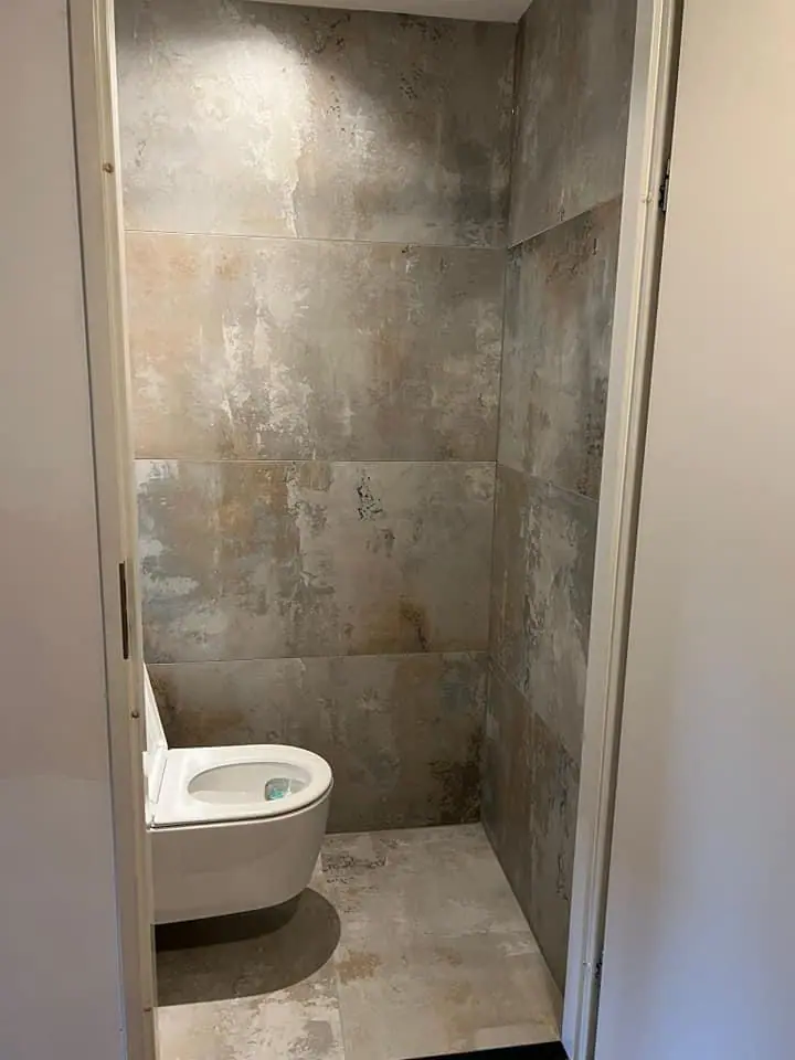 Toiletruimte met grote natuursteenlook tegels