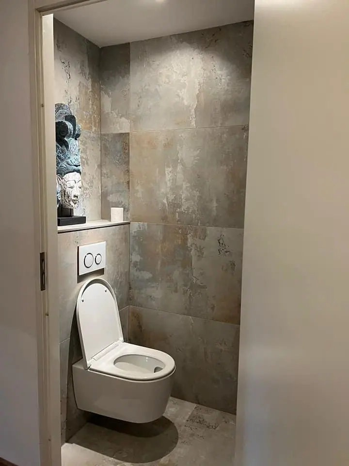 Toilet met grijze tegelwanden