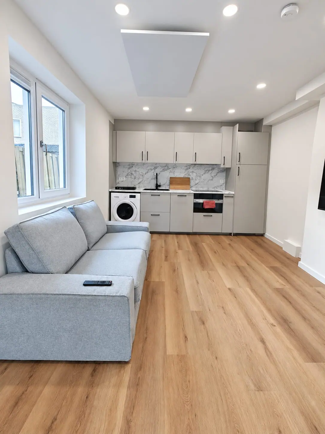 Vernieuwde woonkamer met keuken, lichte vloer en zithoek